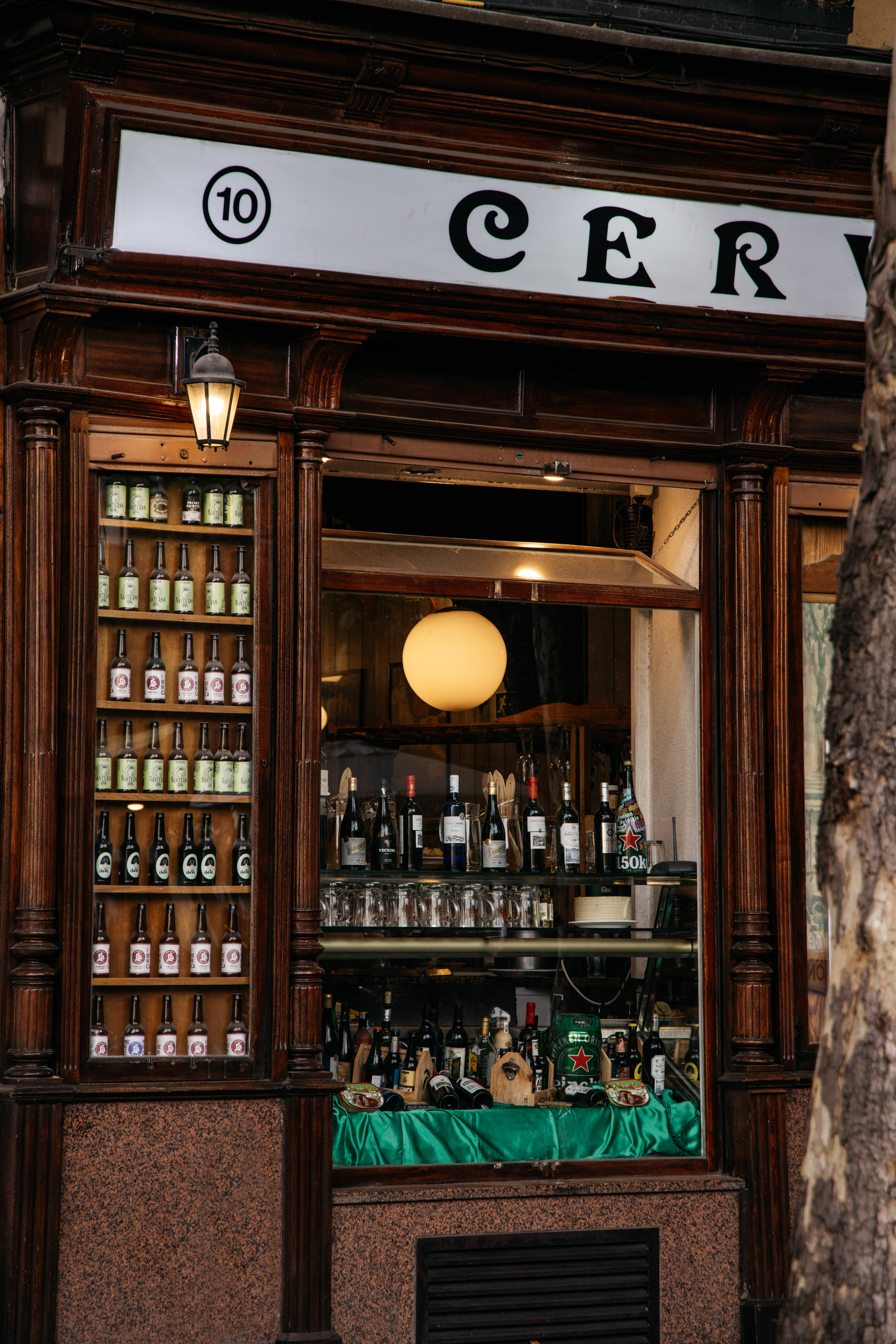 A shop front featuring a sign and displays of alcohol bottles.