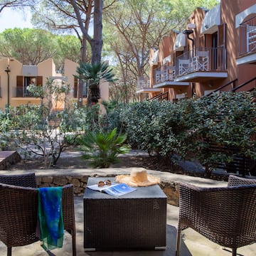 a patio with chairs and a table in front of a building