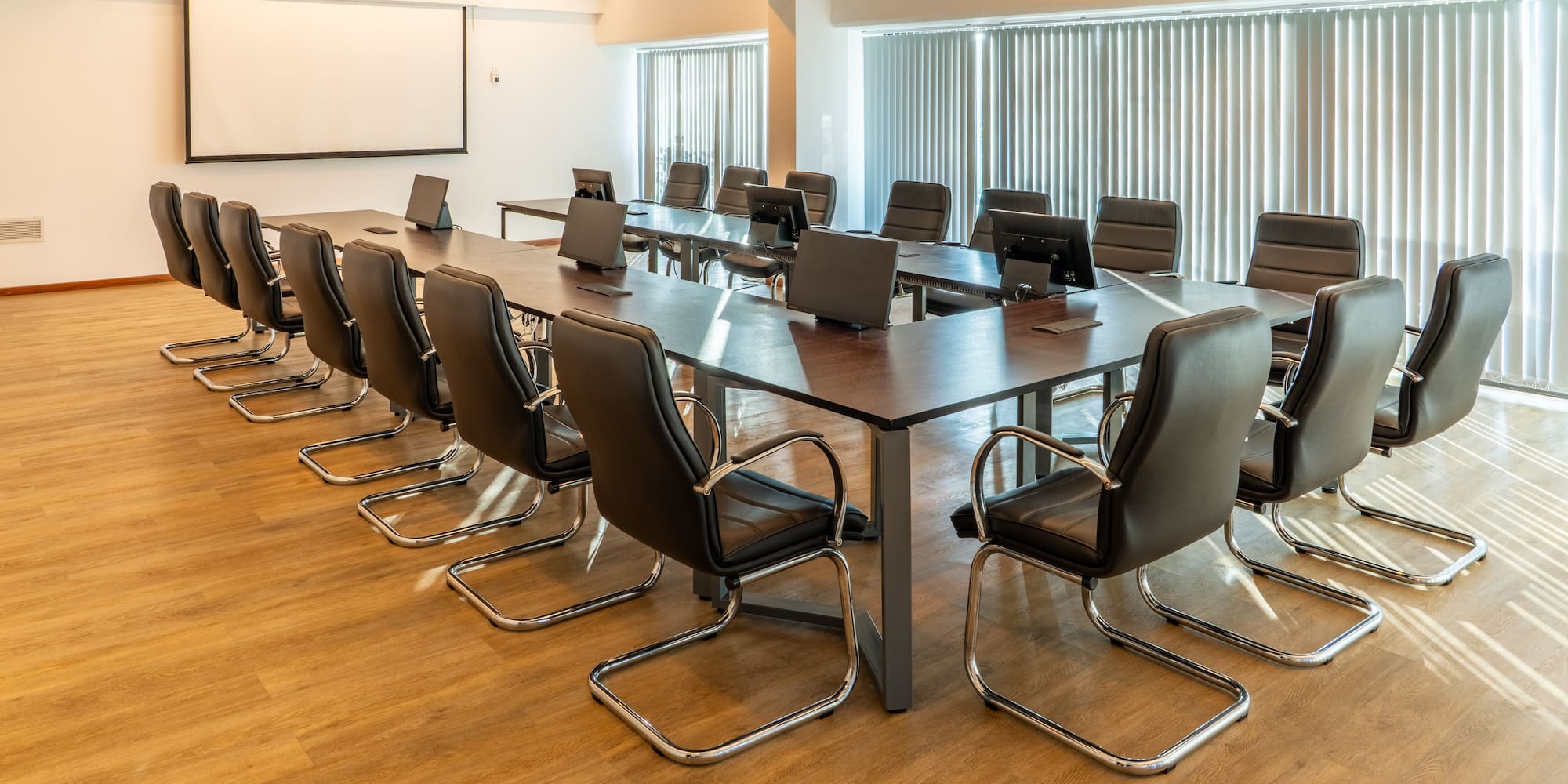 a conference room with chairs and laptops