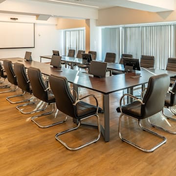 a conference room with chairs and laptops