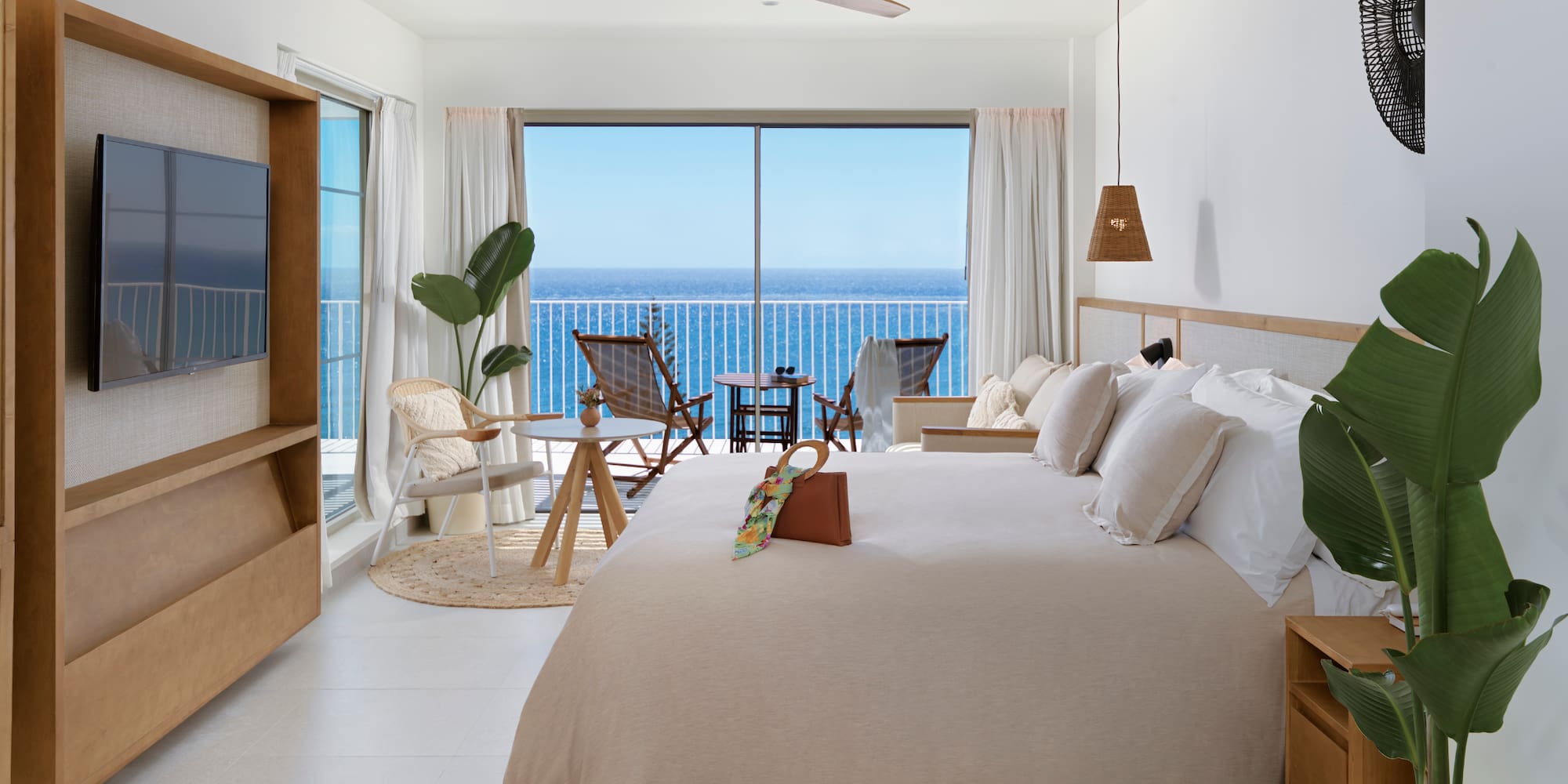 a bedroom with a large window overlooking the ocean