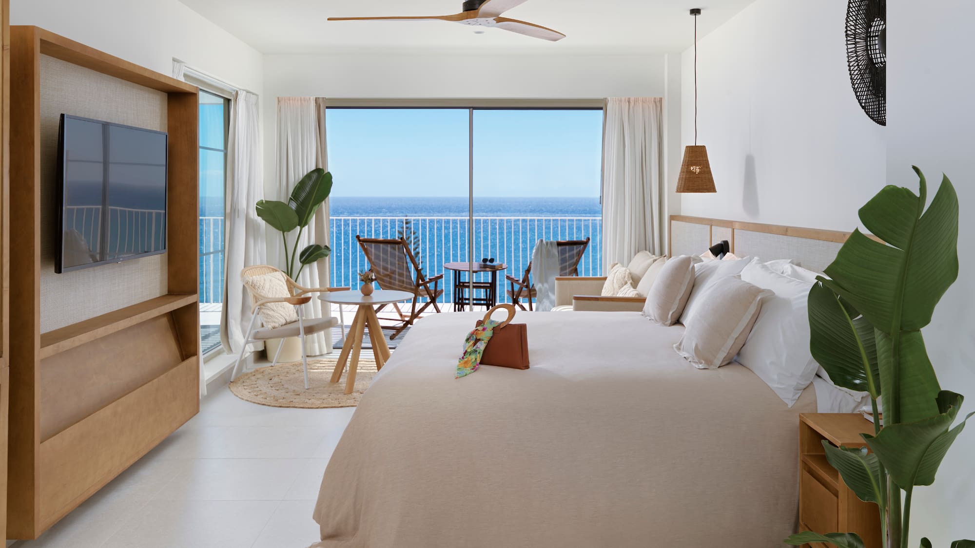a bedroom with a large window overlooking the ocean