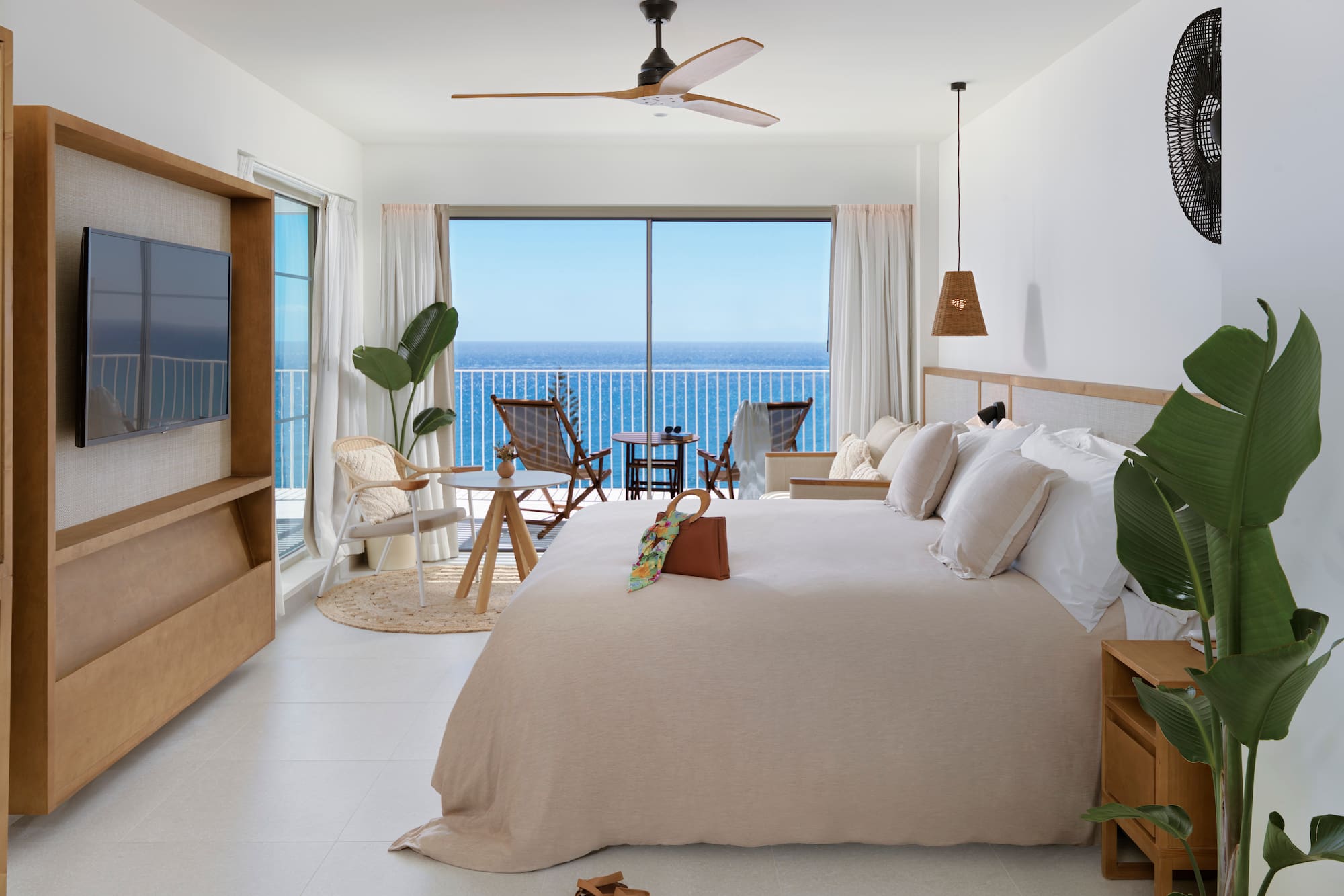 a bedroom with a large window overlooking the ocean