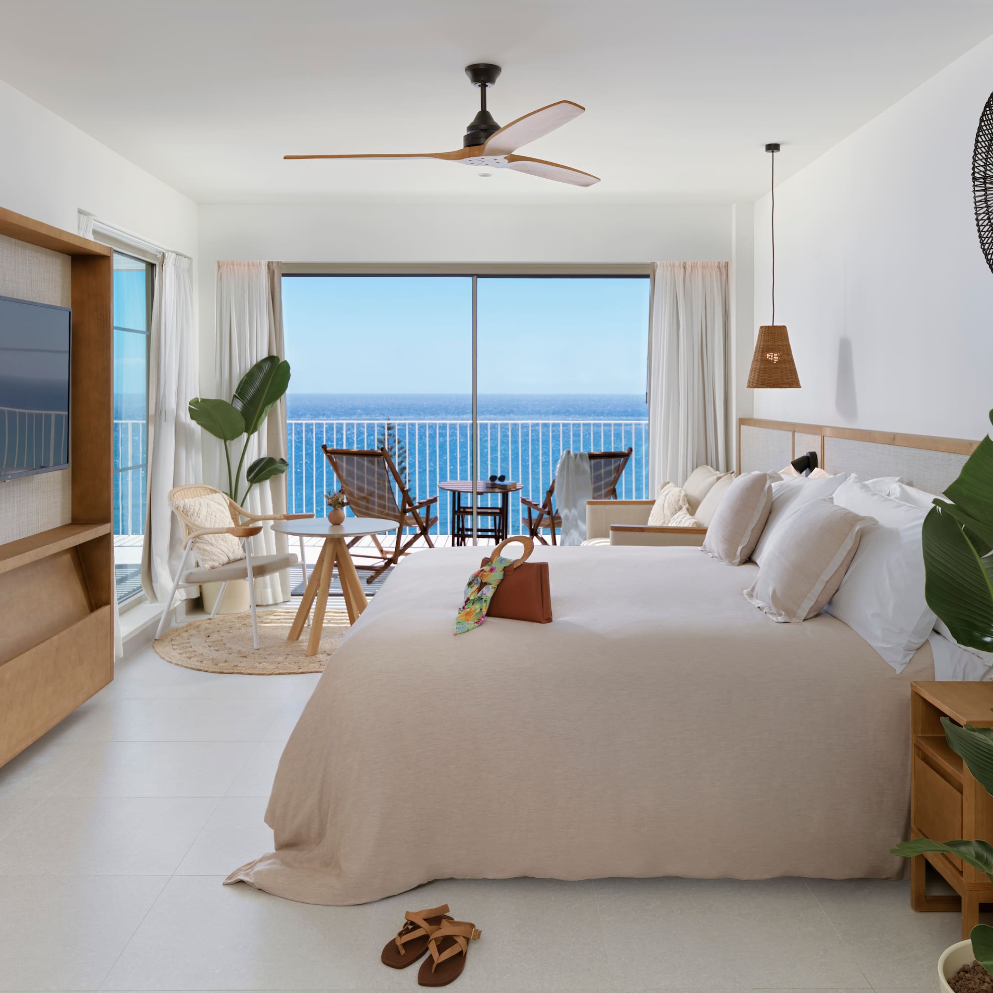 a bedroom with a large window overlooking the ocean