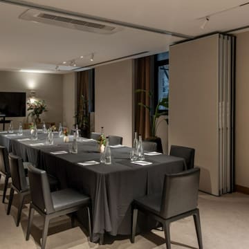 a long table with black tablecloth and chairs