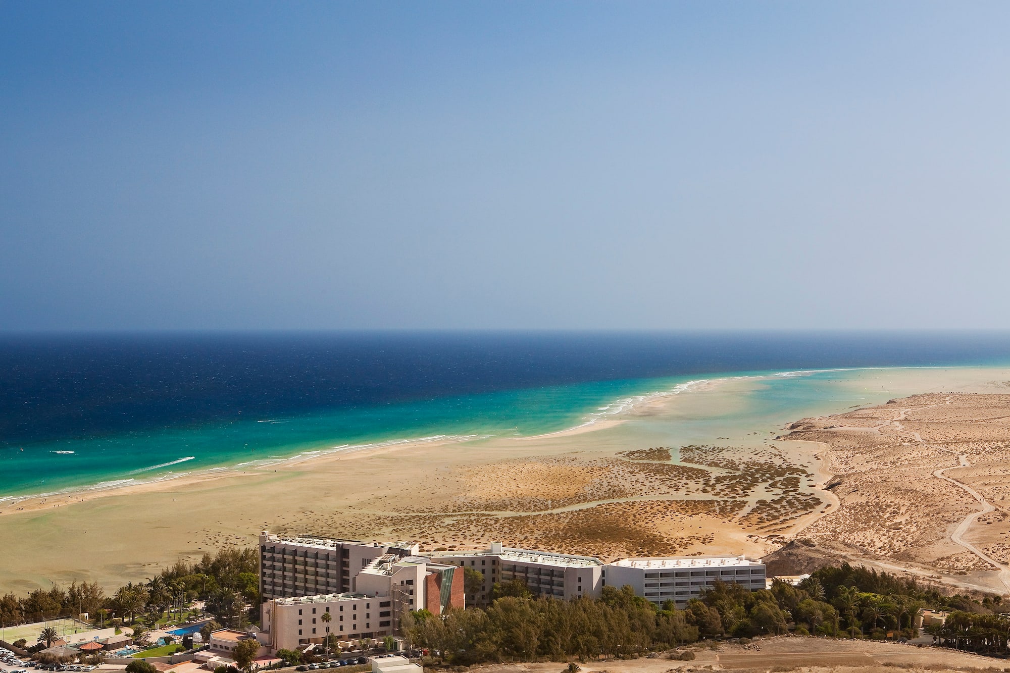 Hotel en Fuerteventura, playa con lagunas de marea y mar turquesa.