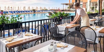 a woman standing at tables outside of a restaurant