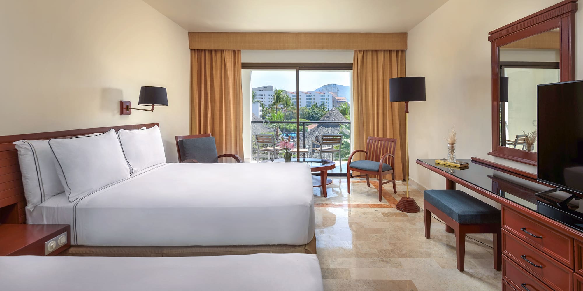 a room with two beds and a table and chairs