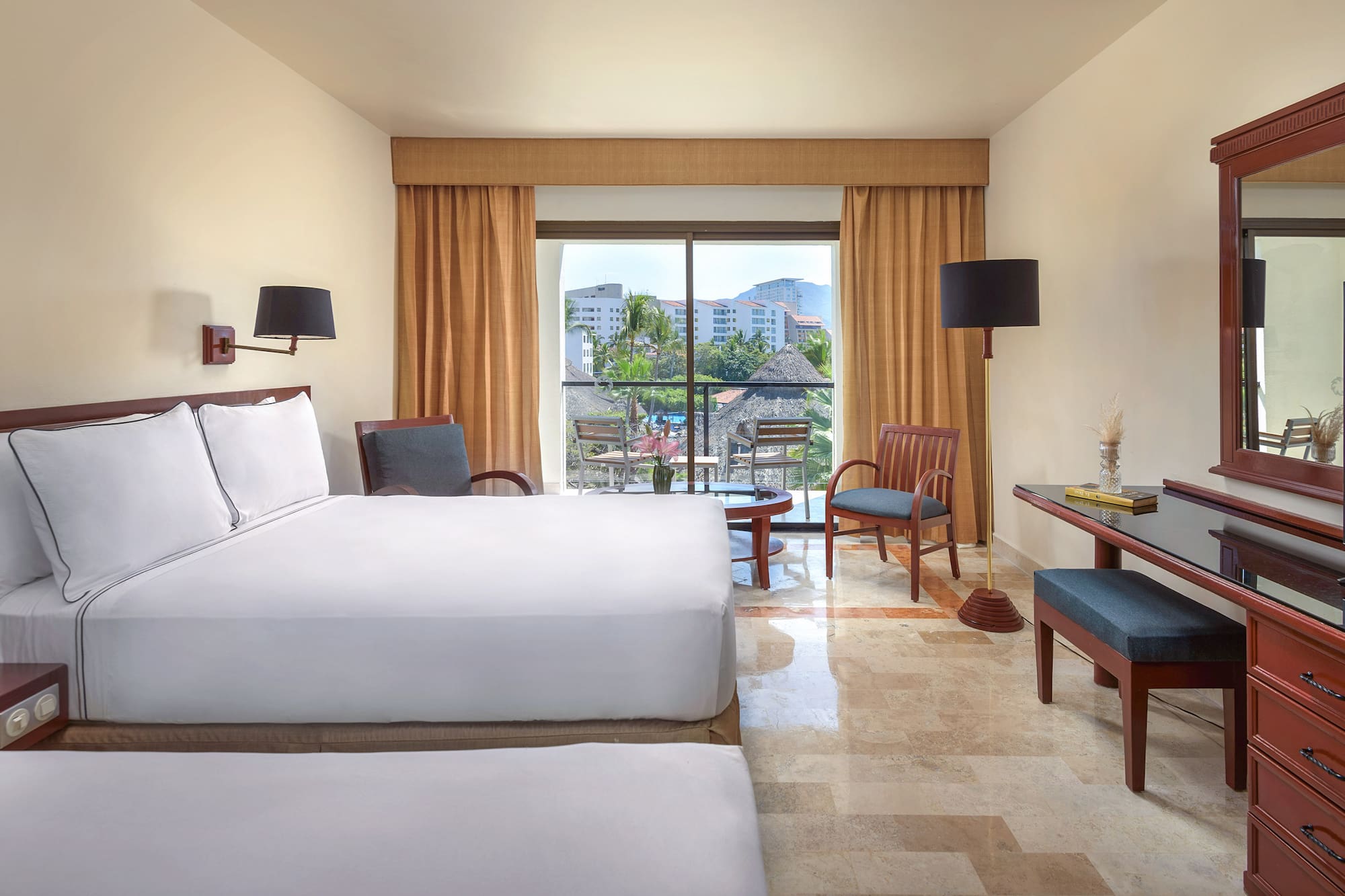 a room with two beds and a table and chairs