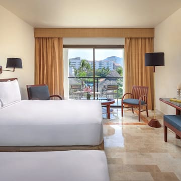 a room with two beds and a table and chairs