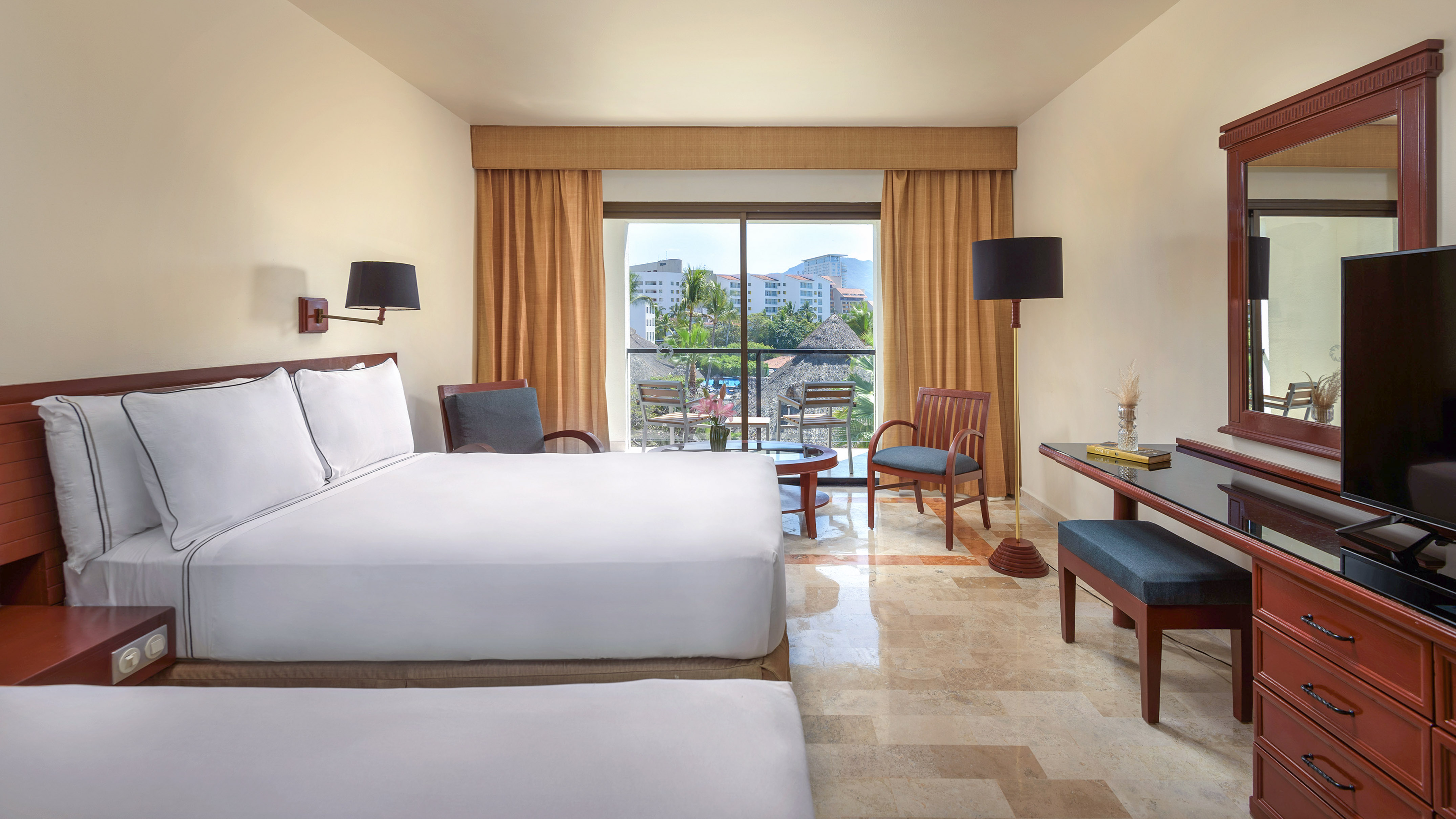 a room with two beds and a table and chairs