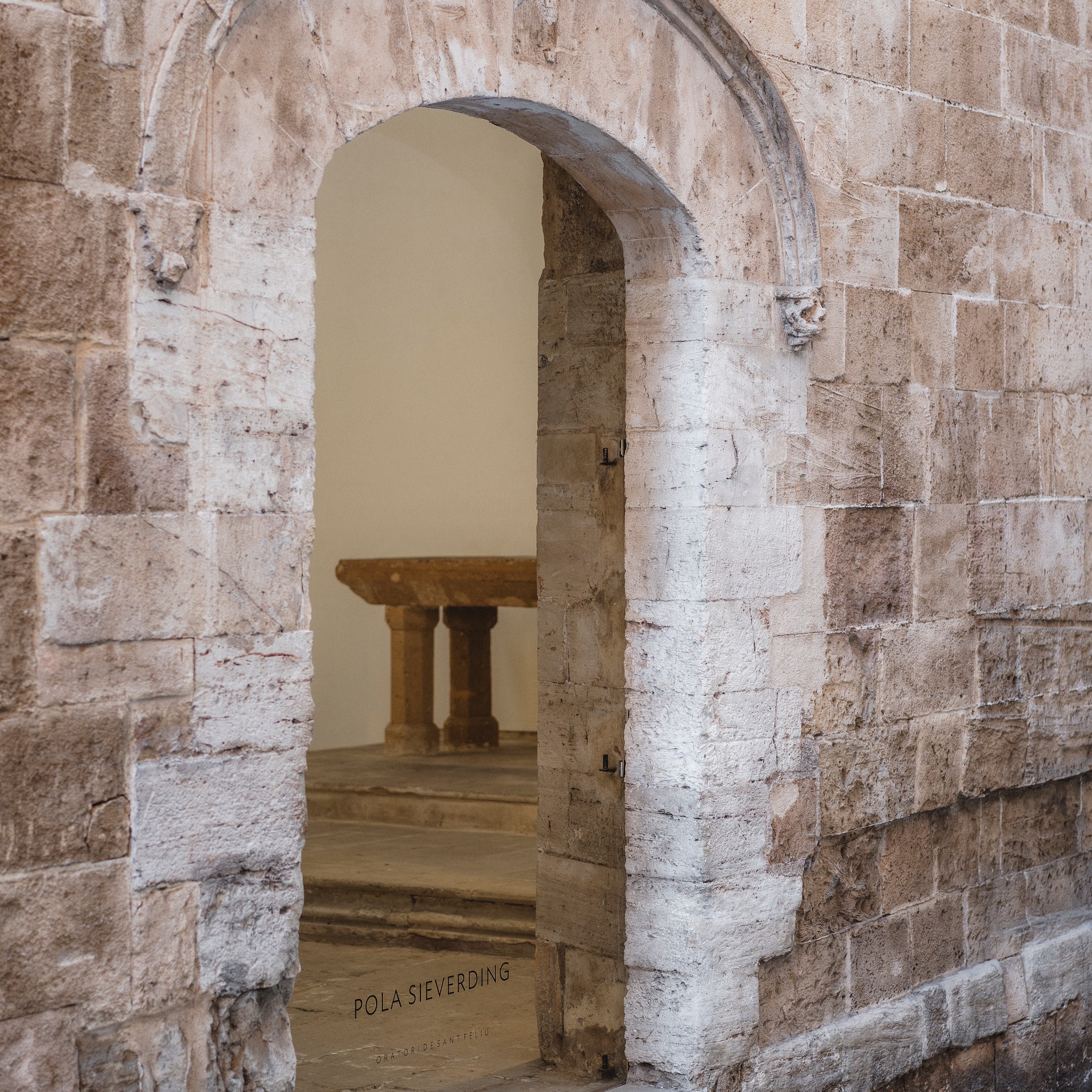 a stone archway with a table in the background