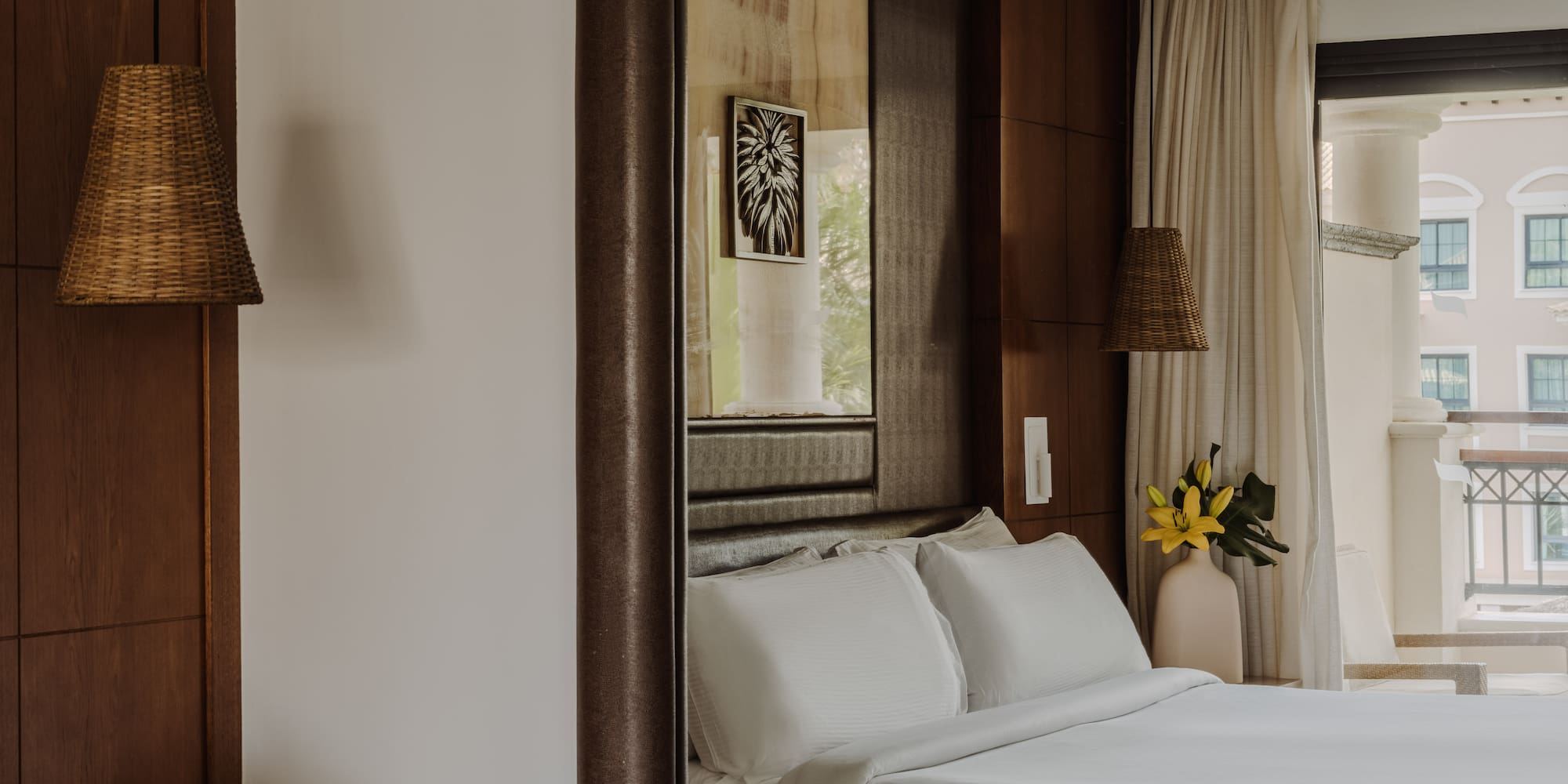 a bedroom with white beds and a mirror