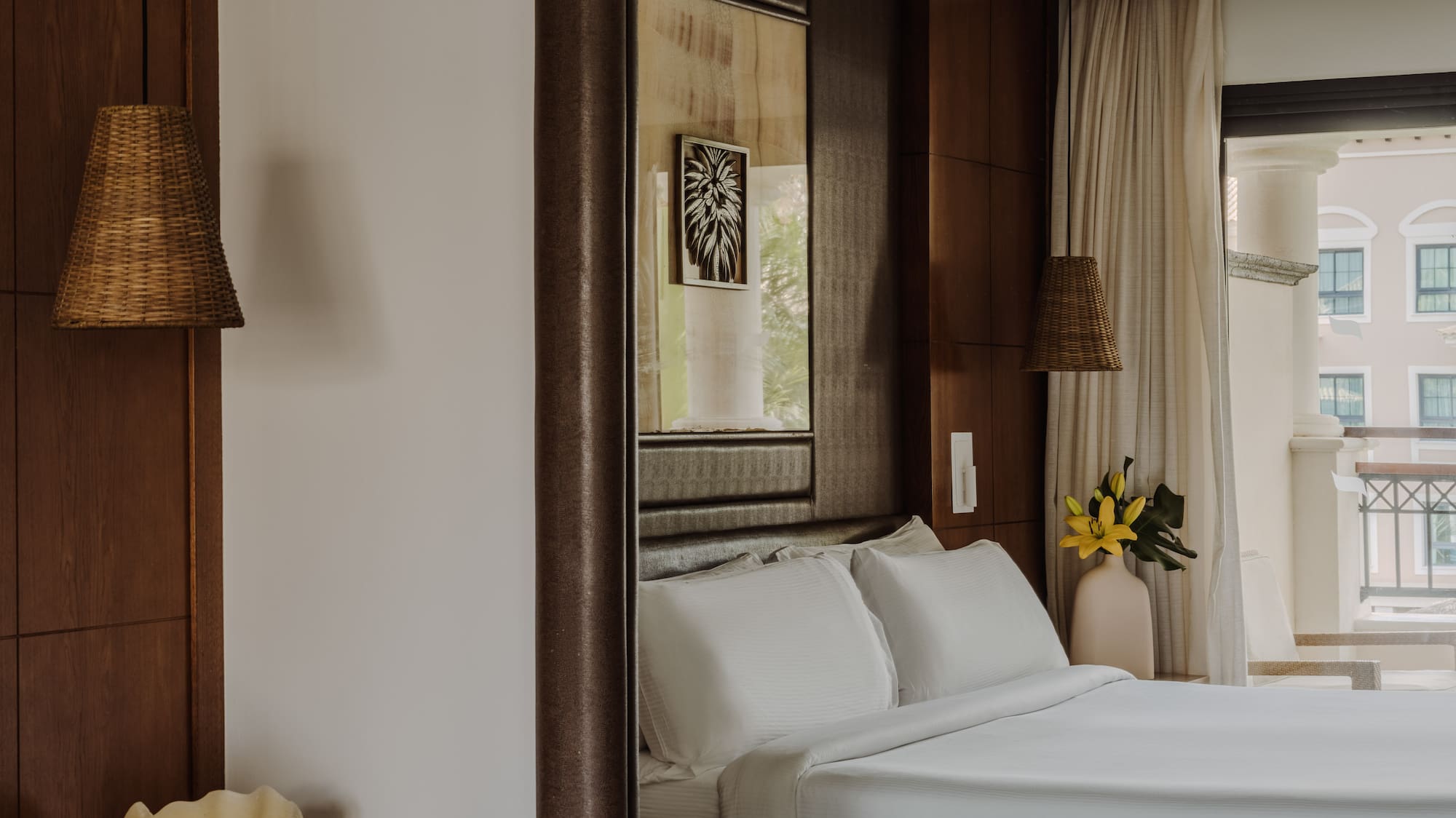 a bedroom with white beds and a mirror