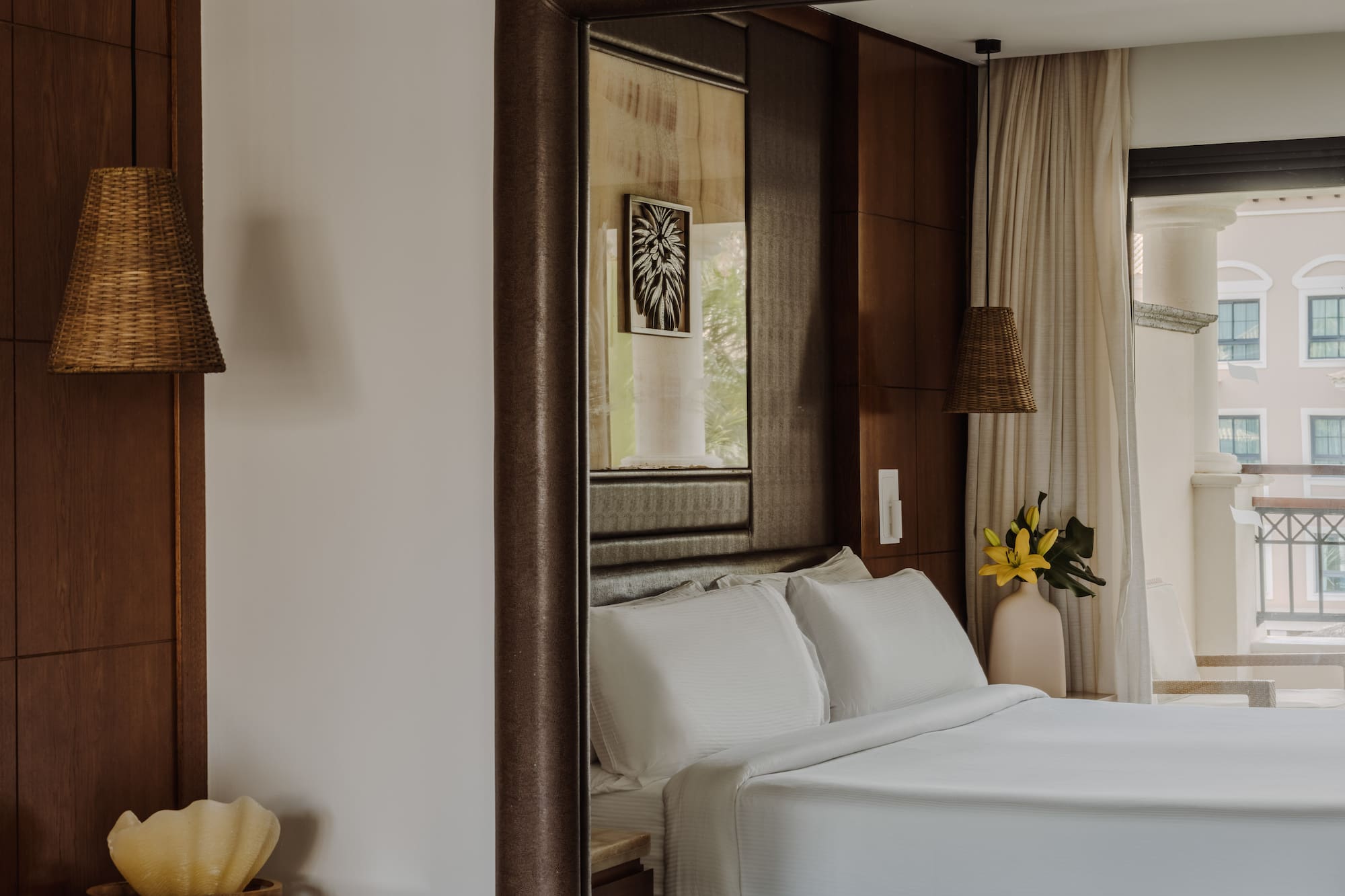 a bedroom with white beds and a mirror