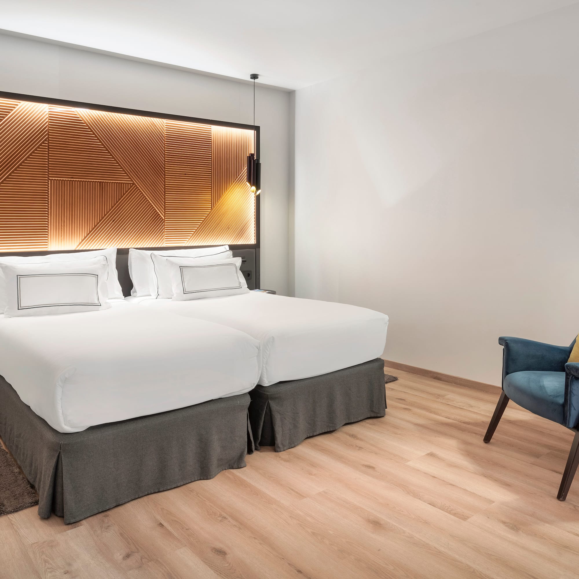 a room with two beds and a chair