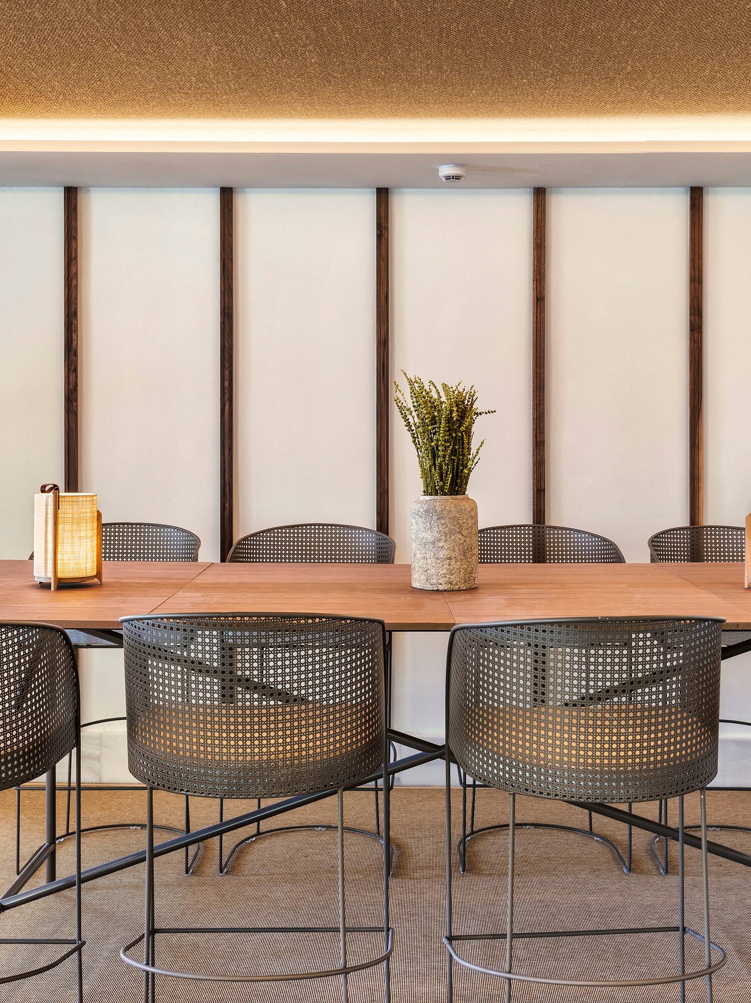 a table with chairs and a vase of flowers
