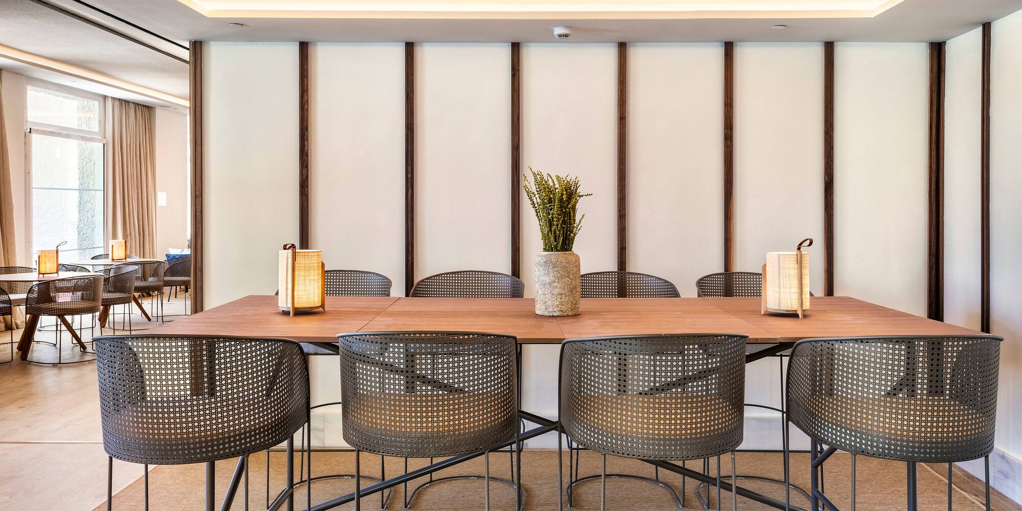 a table with chairs and a vase of flowers