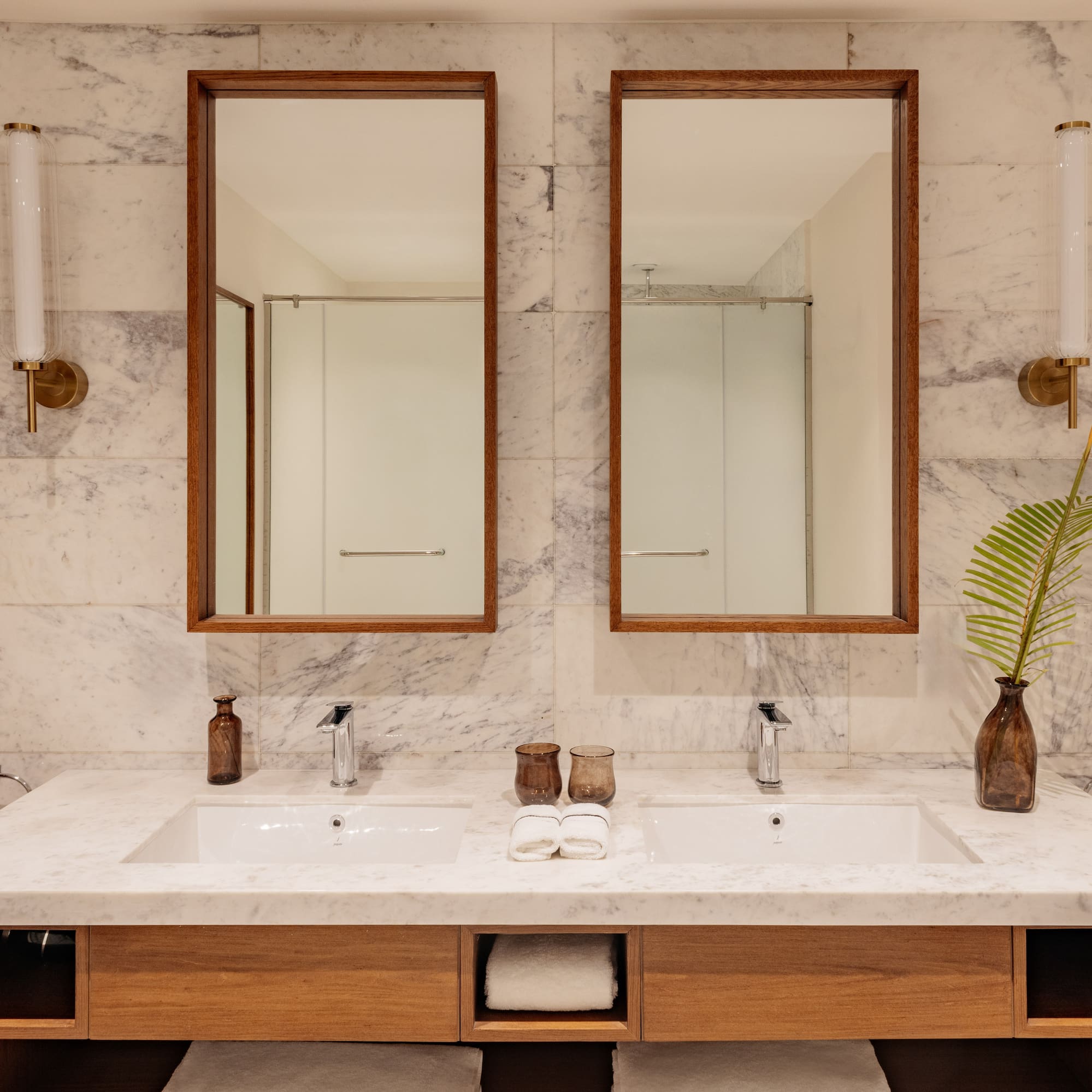 a bathroom with marble countertop sinks and mirrors