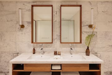 a bathroom with marble countertop sinks and mirrors