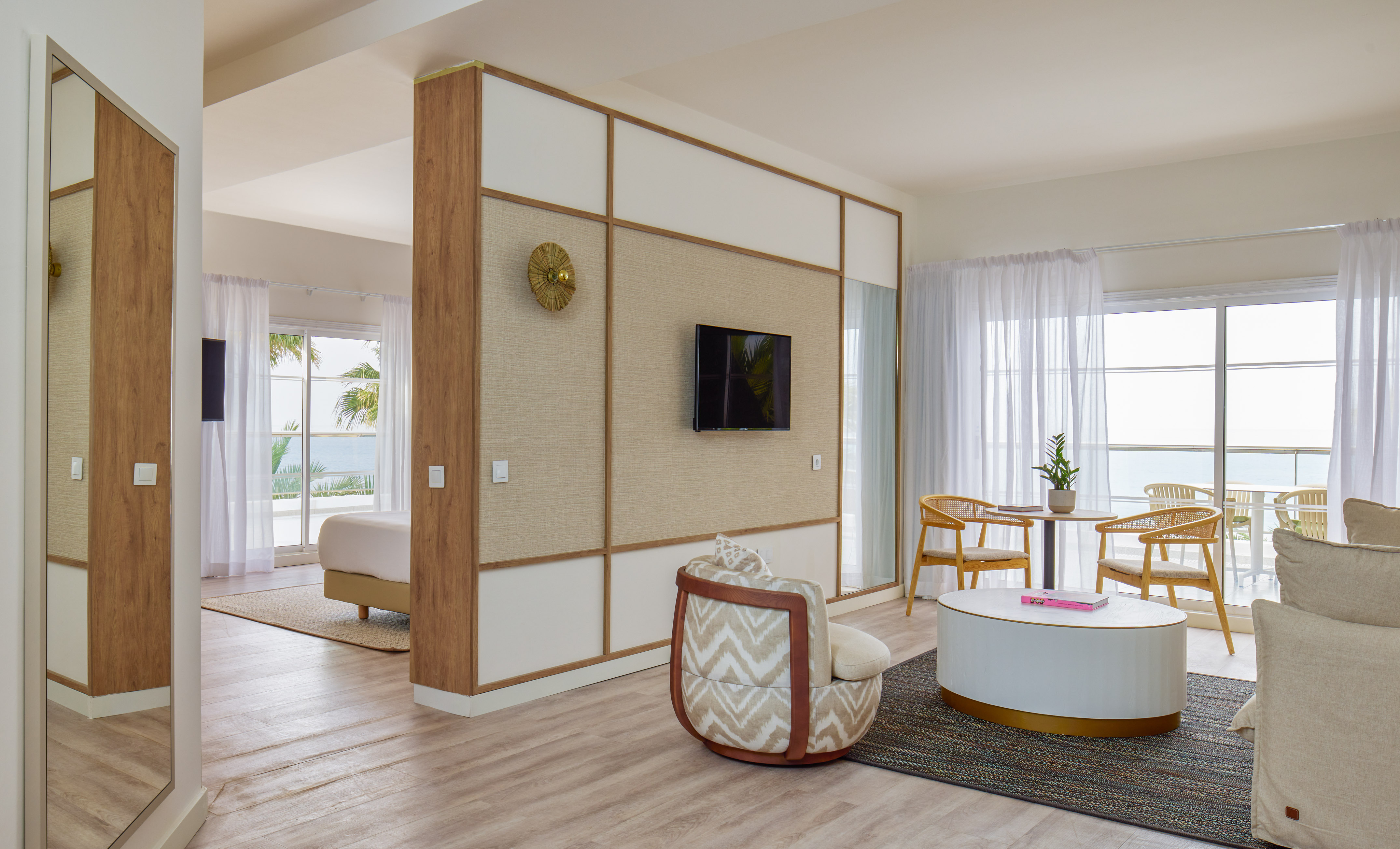 Oceanfront hotel suite with living room, bedroom, and balcony view.