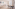 Bright studio apartment with sofa, dining table, and balcony access.