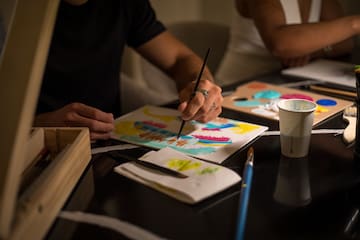 a person painting on a paper