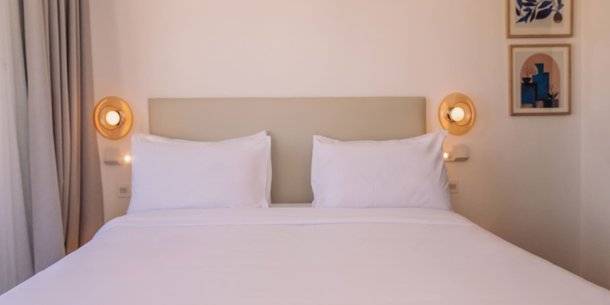 a bed with white sheets and pillows