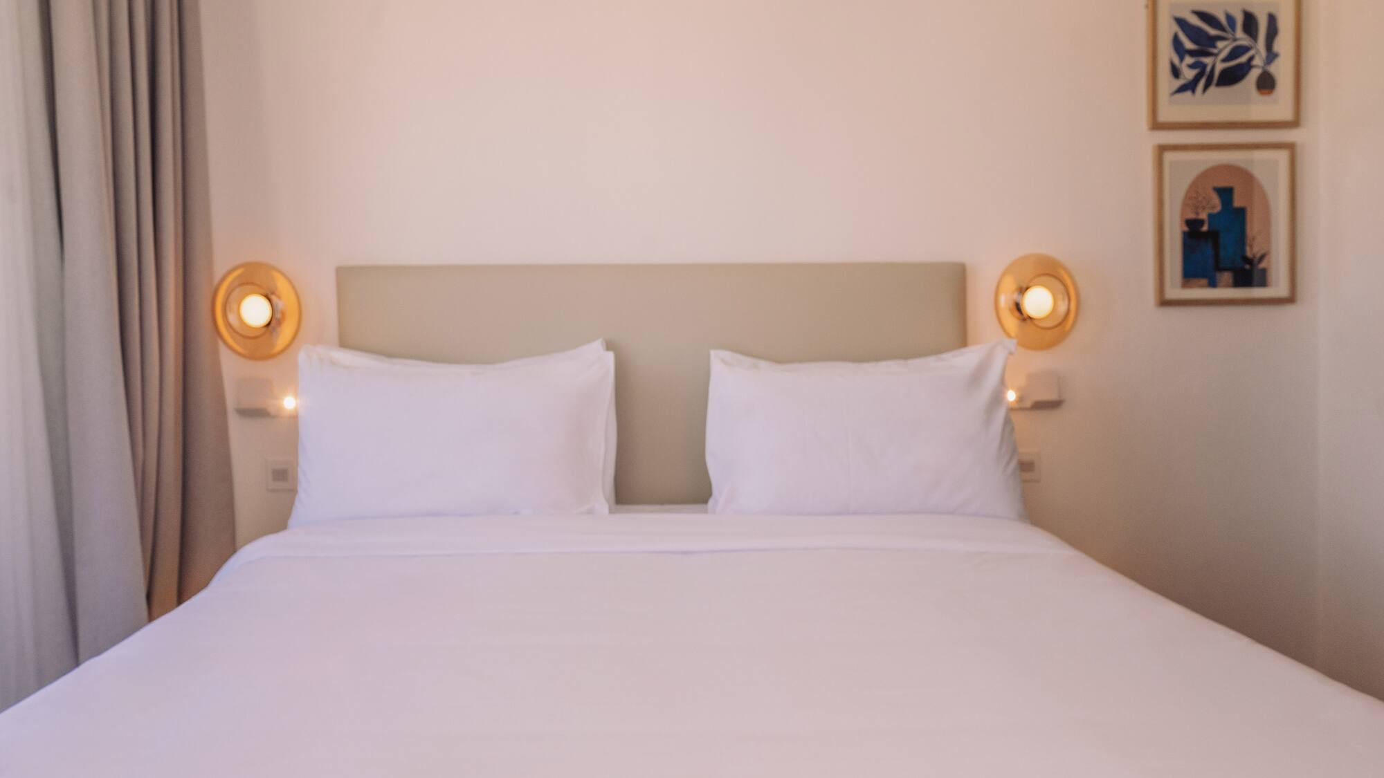a bed with white sheets and pillows
