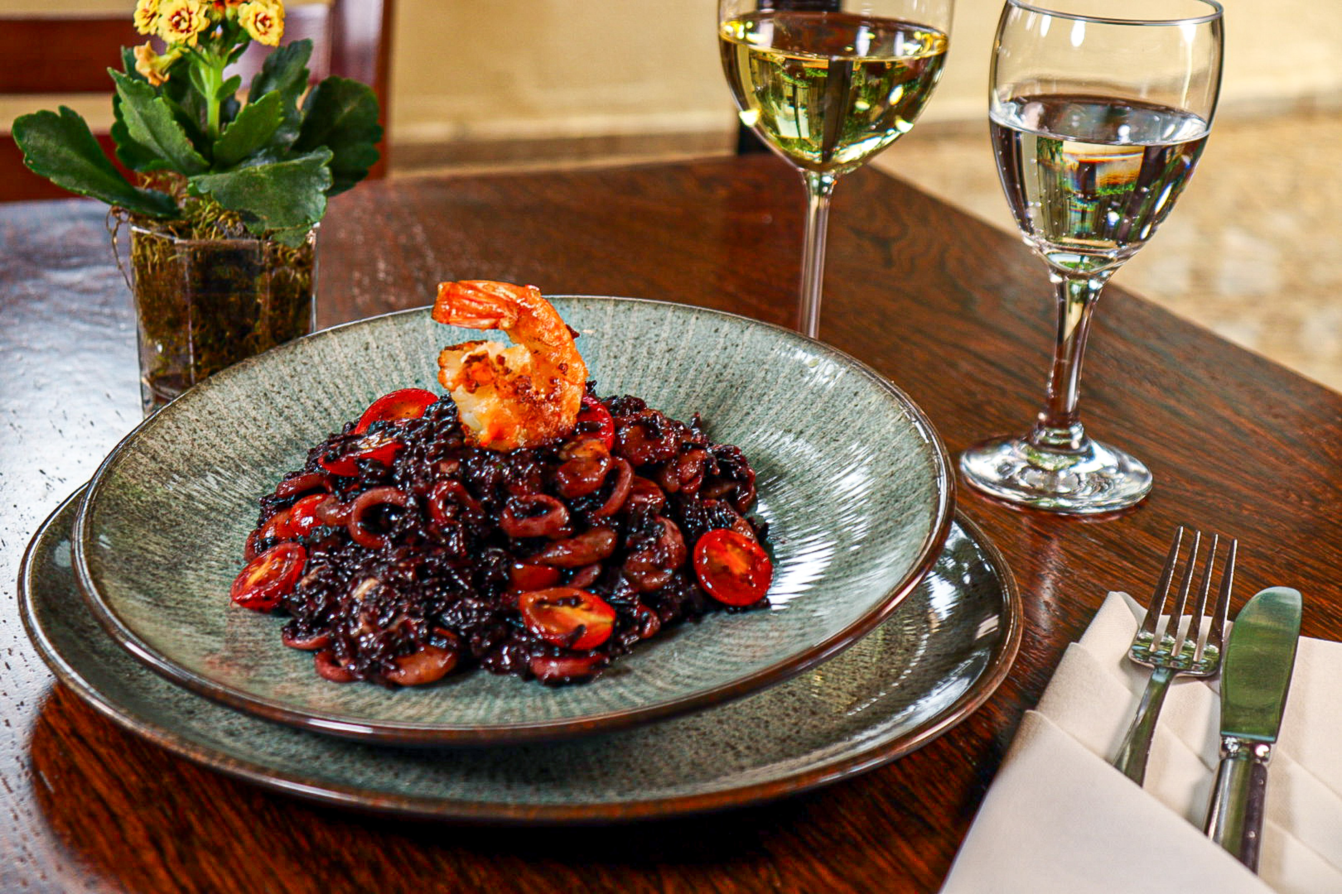 Black squid ink risotto with shrimp, tomatoes, and white wine.