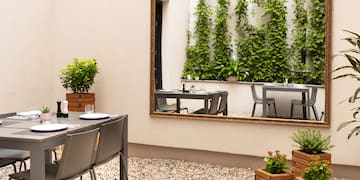 a mirror on a wall with a table and chairs