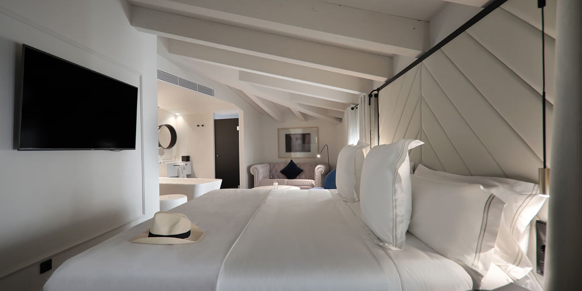 a bed with white sheets and a hat on it