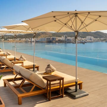 a pool with lounge chairs and umbrellas