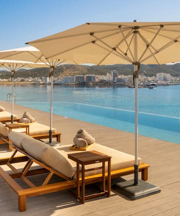 a pool with lounge chairs and umbrellas