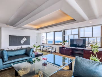 a living room with a glass table and a television