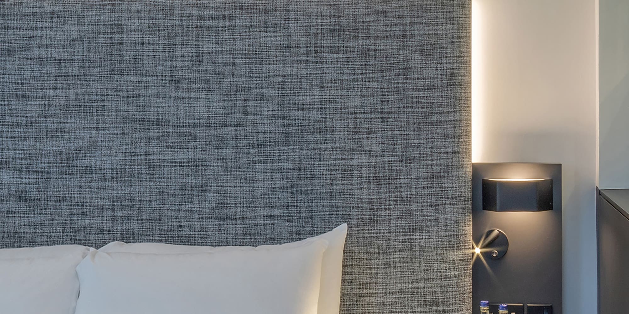 a bed with a table and two bottles of water on it