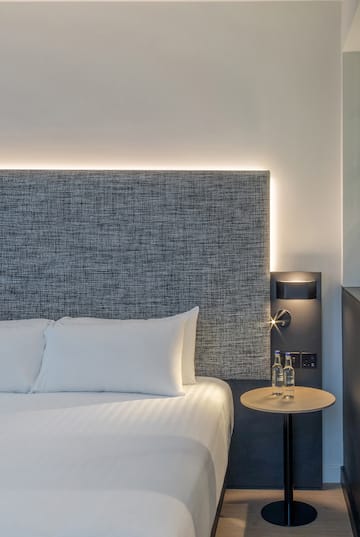 a bed with a table and two bottles of water on it