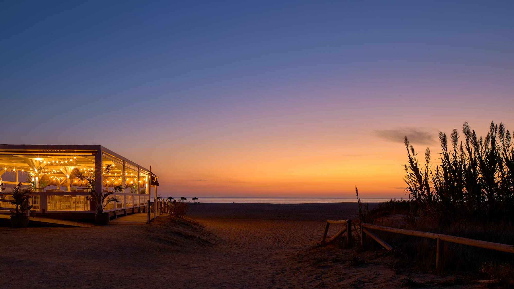 a building with lights on the beach