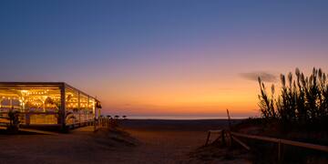 a building with lights on the beach