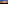 Illuminated beach bar at dusk, sandy path to ocean, colorful sunset sky.