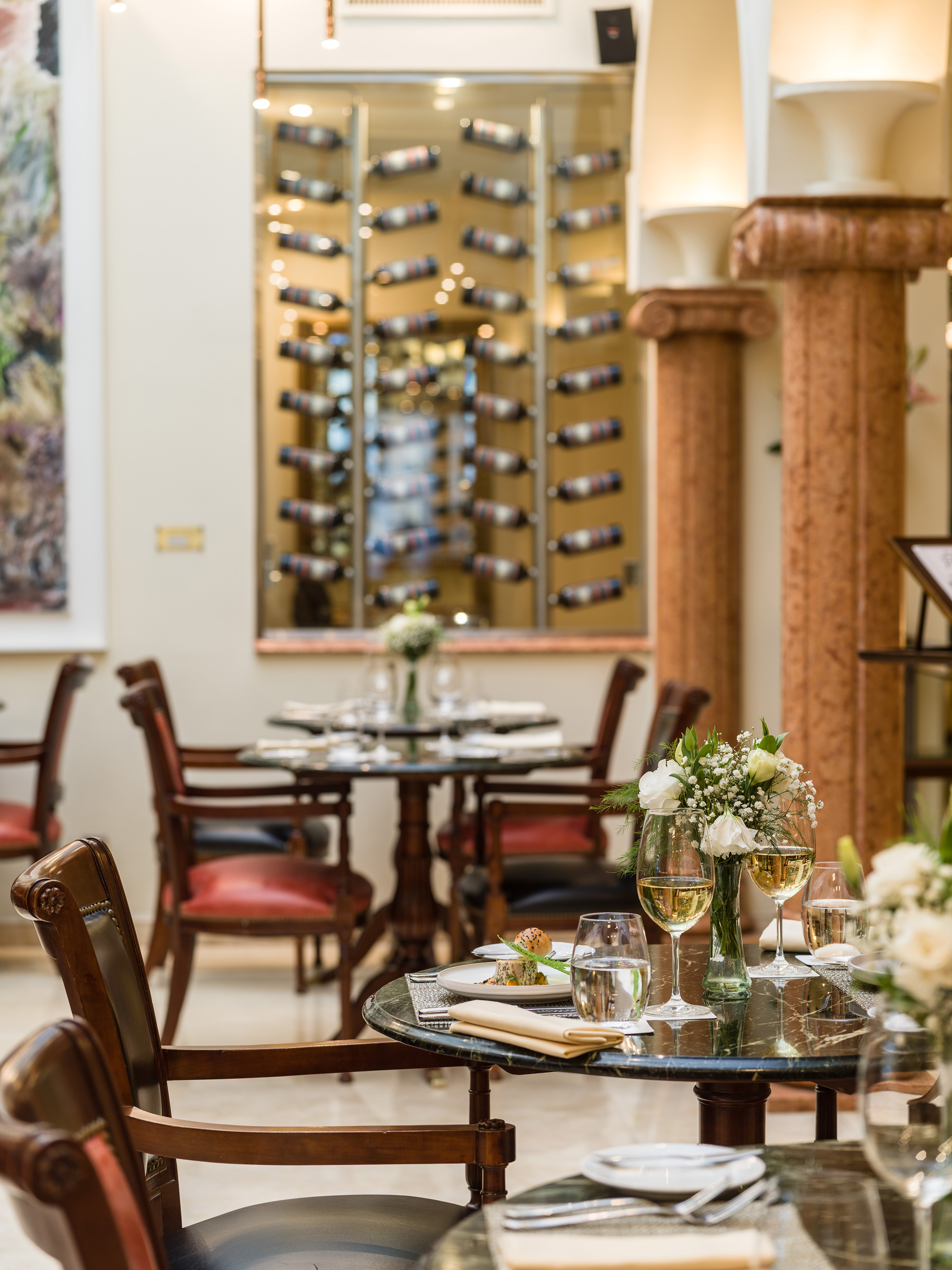 Elegant restaurant dining tables with white wine and a glass wine cellar. - 1557 Bistro, Lokale keuken - Melia Recoleta Plaza, Buenos Aires