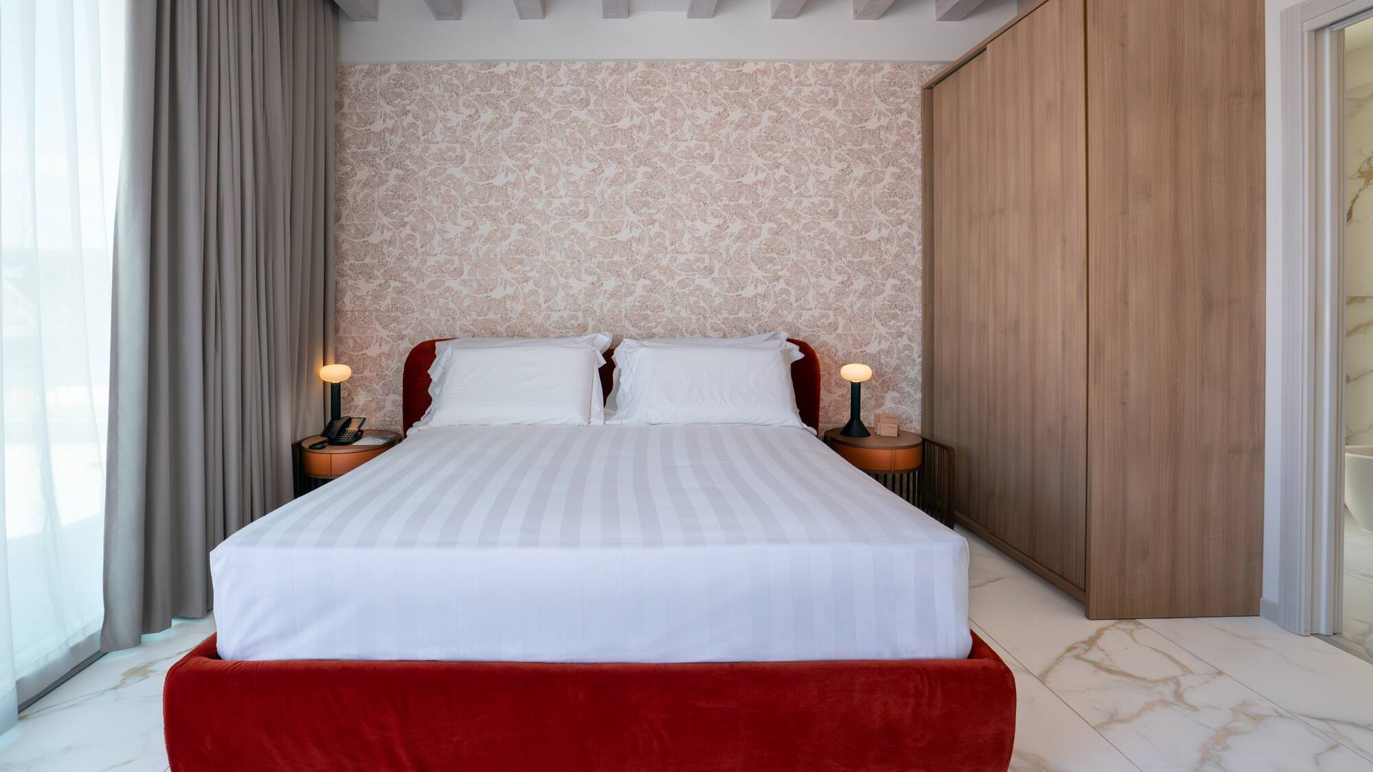 a bed with a red bed frame and a wood cabinet