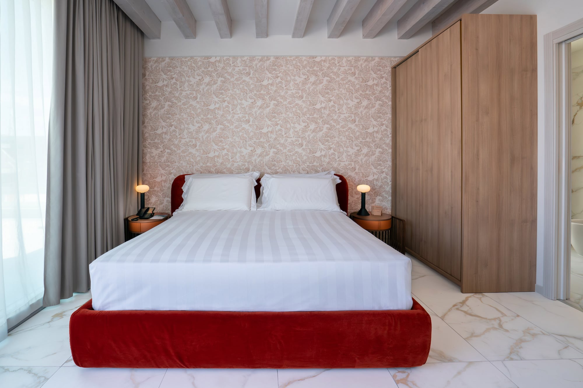 a bed with a red bed frame and a wood cabinet