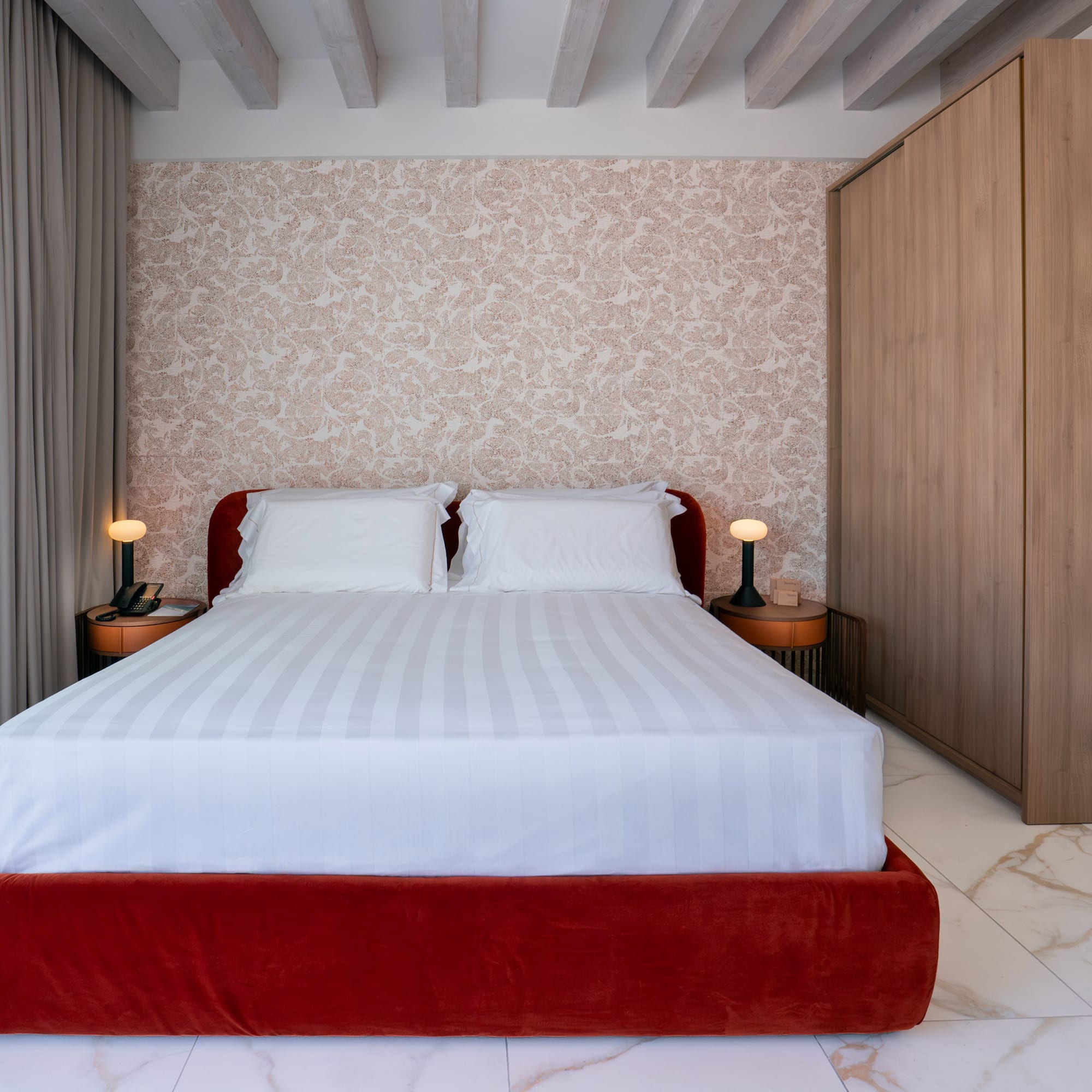a bed with a red bed frame and a wood cabinet