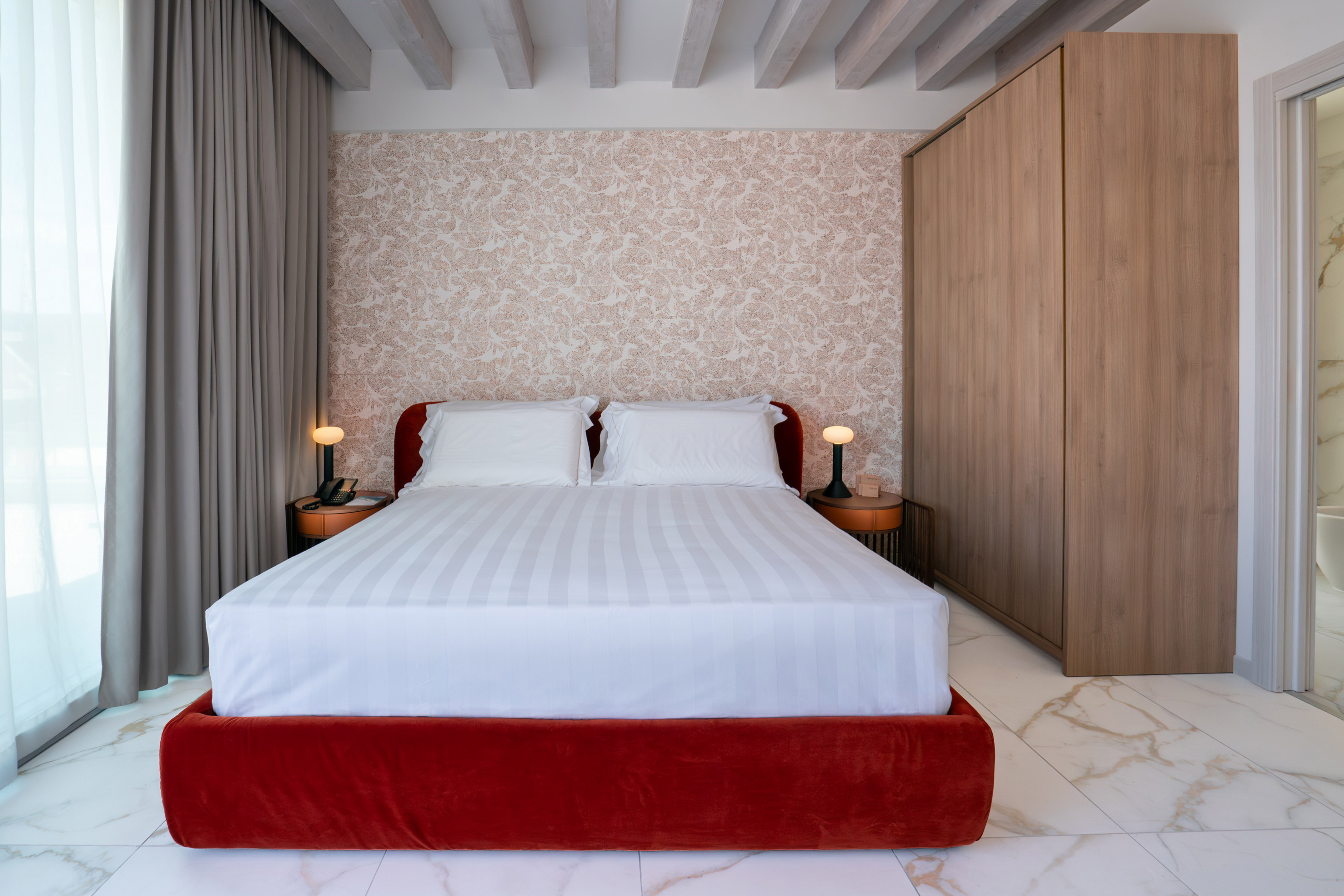 a bed with a red bed frame and a wood cabinet