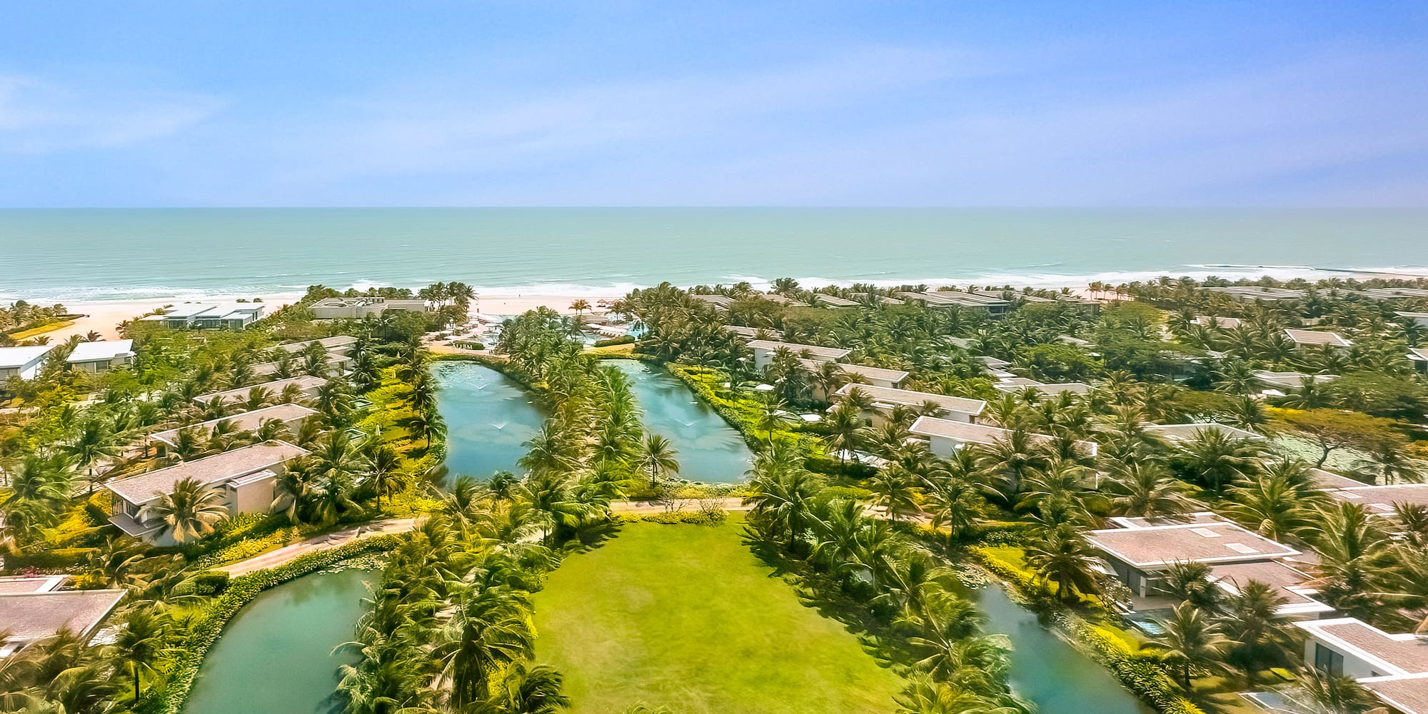 a aerial view of a resort with a body of water and a beach