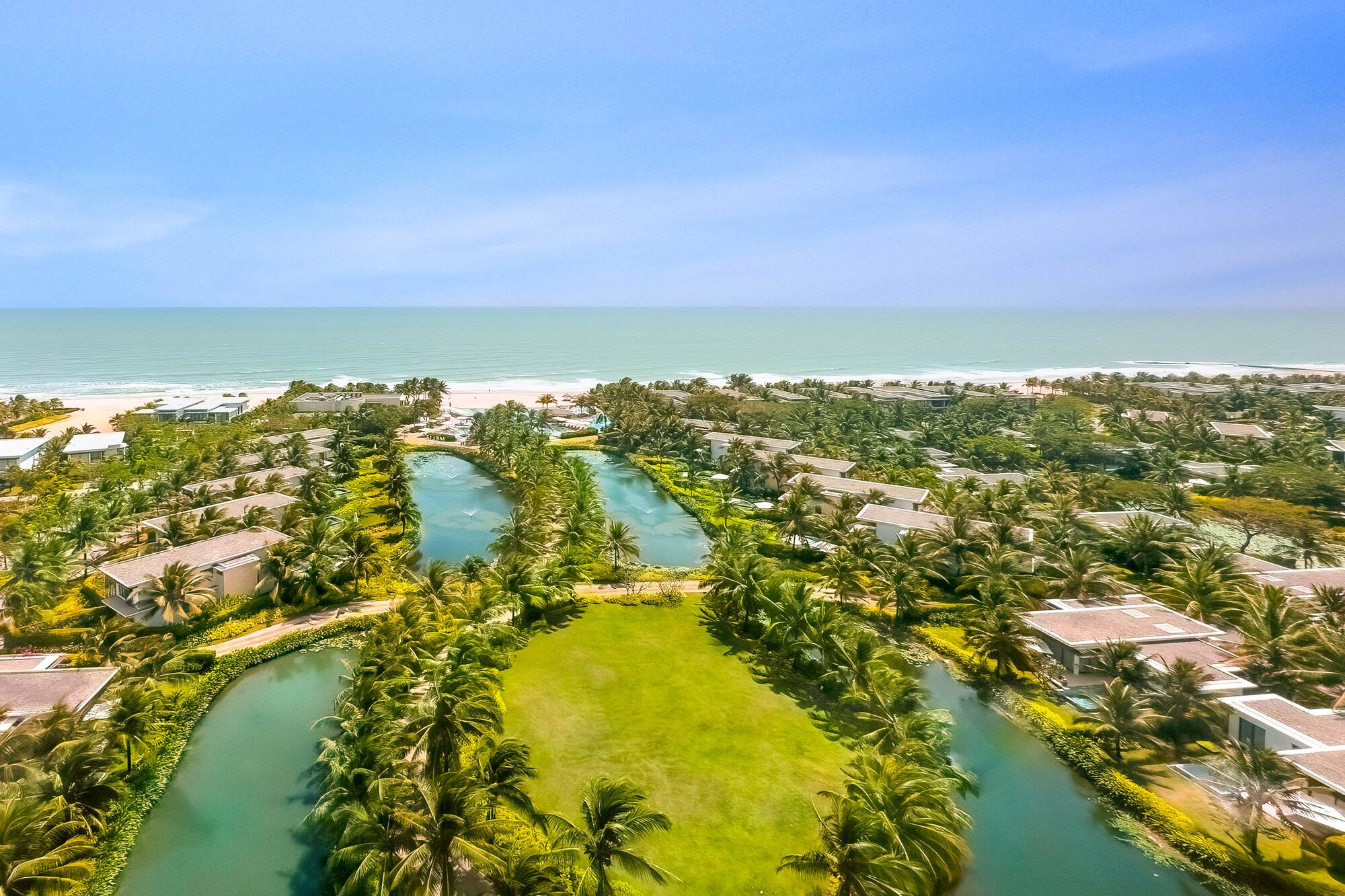 a aerial view of a resort with a body of water and a beach