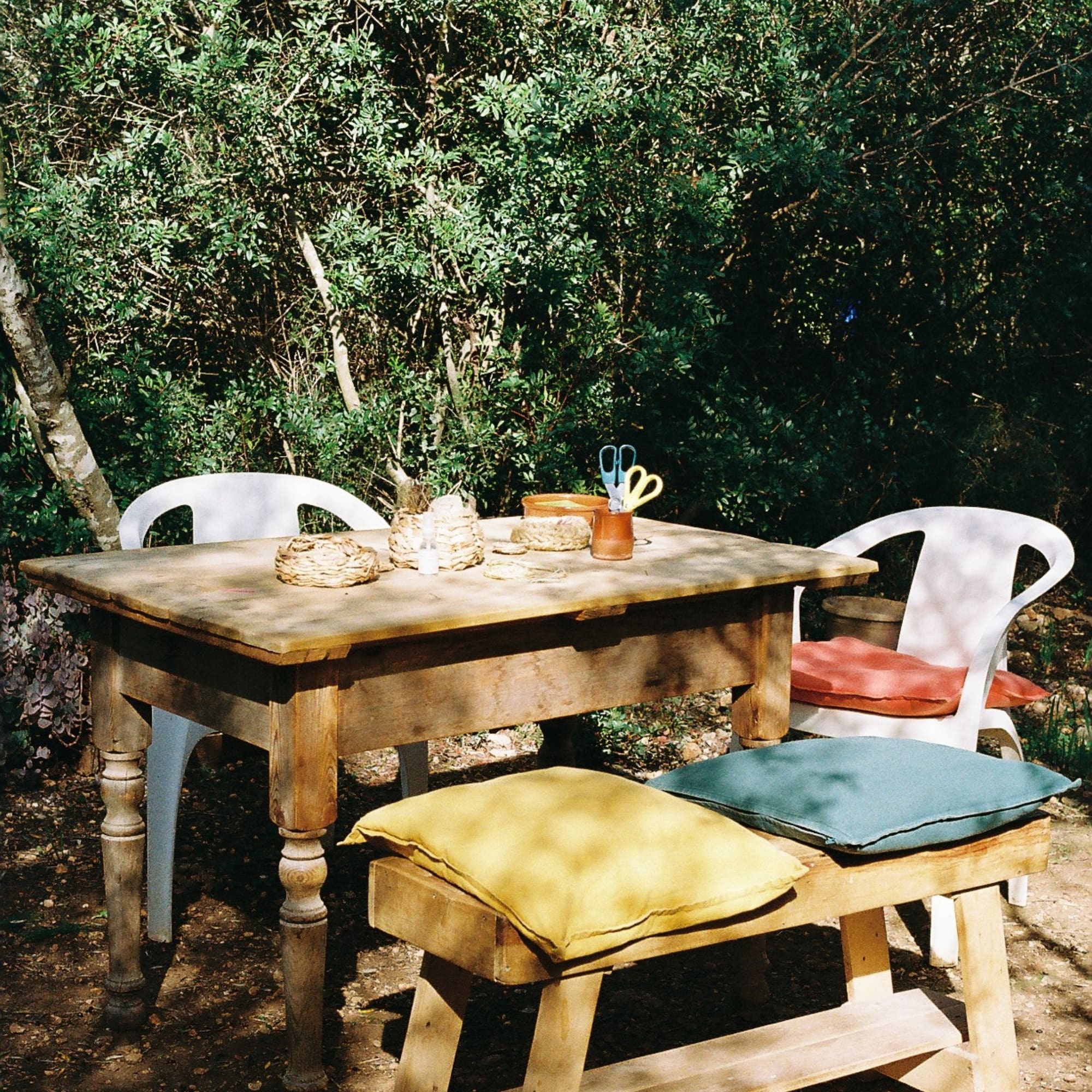a table and chairs in a forest