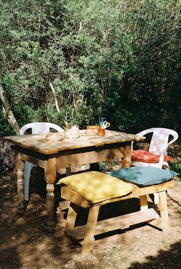 a table and chairs in a forest