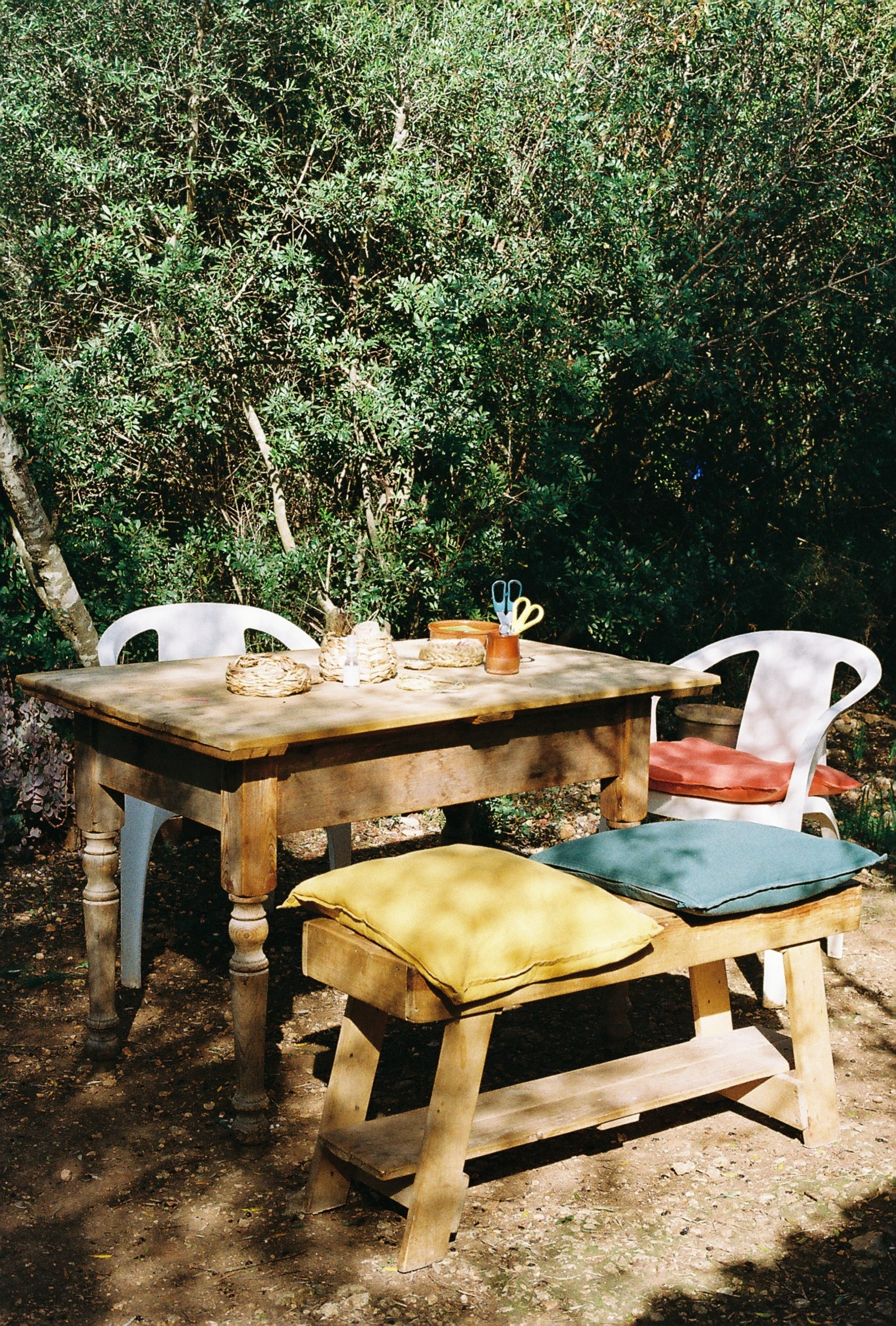 a table and chairs in a forest